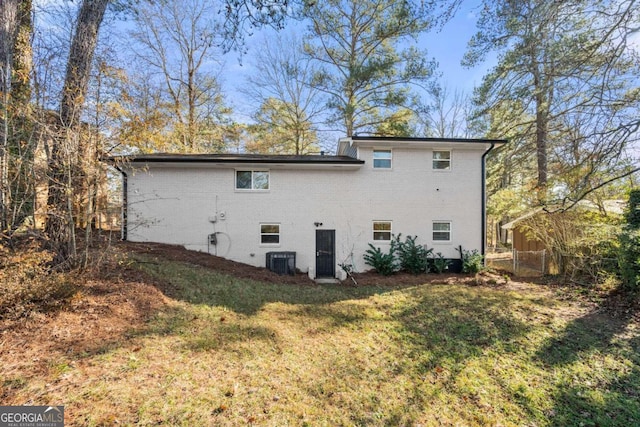 back of house with a lawn and central AC