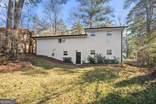 back of house featuring central AC and a lawn