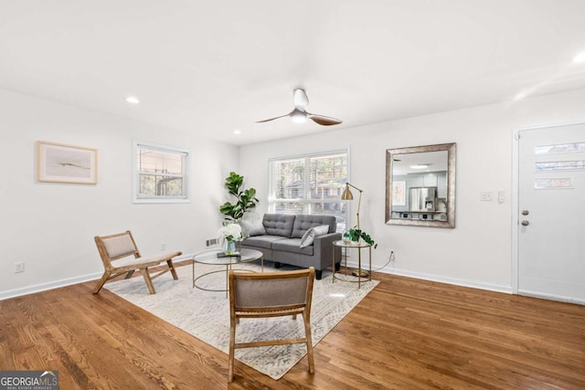 living room featuring hardwood / wood-style floors and ceiling fan