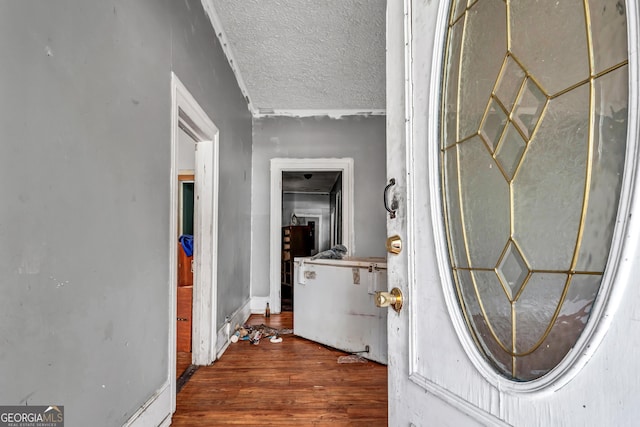 hallway with a textured ceiling and hardwood / wood-style flooring