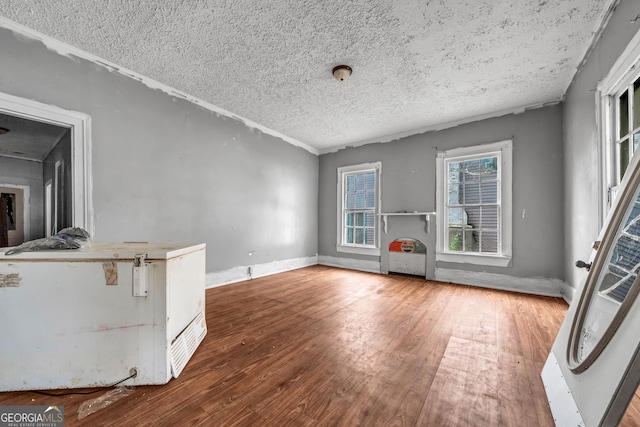 unfurnished living room featuring a textured ceiling and hardwood / wood-style flooring