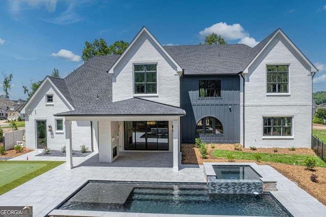 back of house with a patio and a pool with hot tub