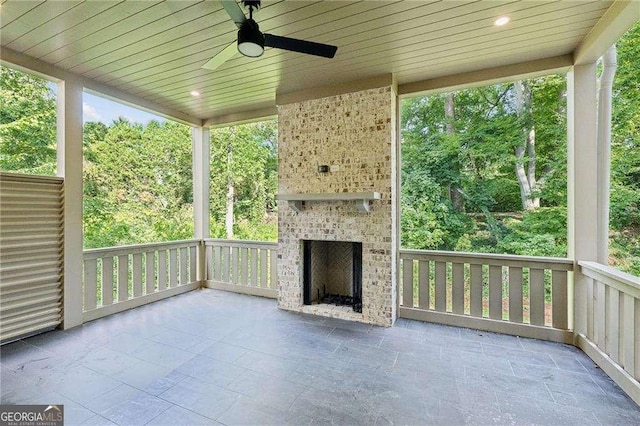 view of patio featuring an outdoor brick fireplace and ceiling fan