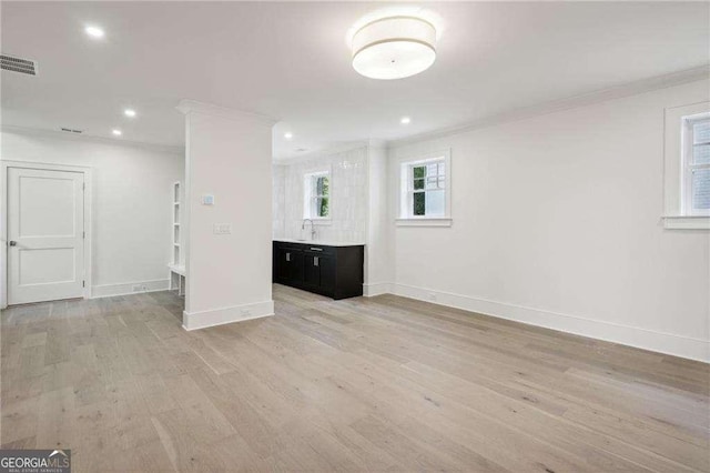 interior space with light hardwood / wood-style flooring, crown molding, and sink