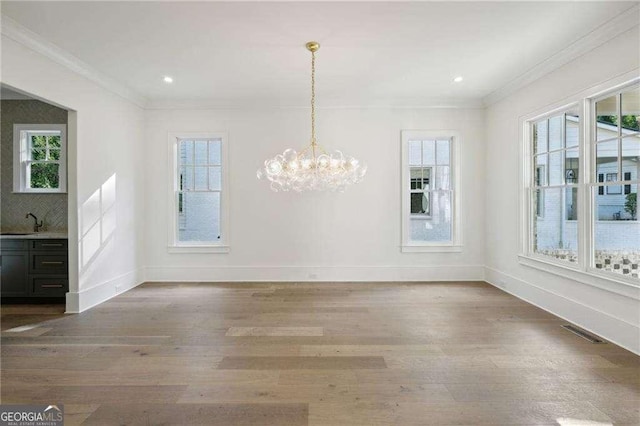 unfurnished dining area with hardwood / wood-style floors, a healthy amount of sunlight, and sink