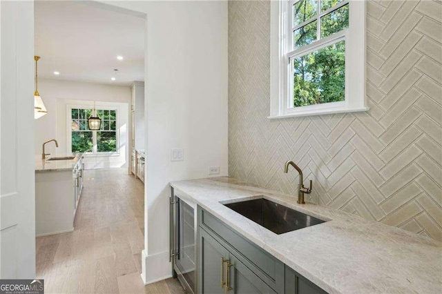 washroom featuring sink, wine cooler, and light hardwood / wood-style flooring