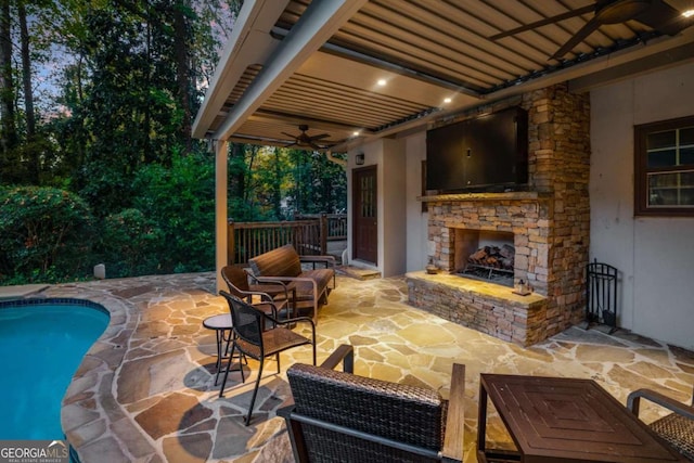 view of patio / terrace featuring an outdoor stone fireplace and ceiling fan