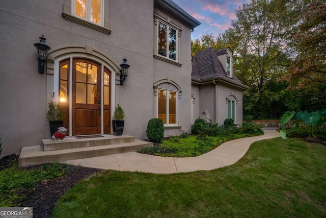 exterior entry at dusk with a lawn