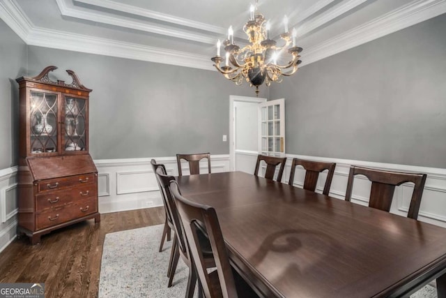 dining room with dark hardwood / wood-style flooring, crown molding, a tray ceiling, and a chandelier