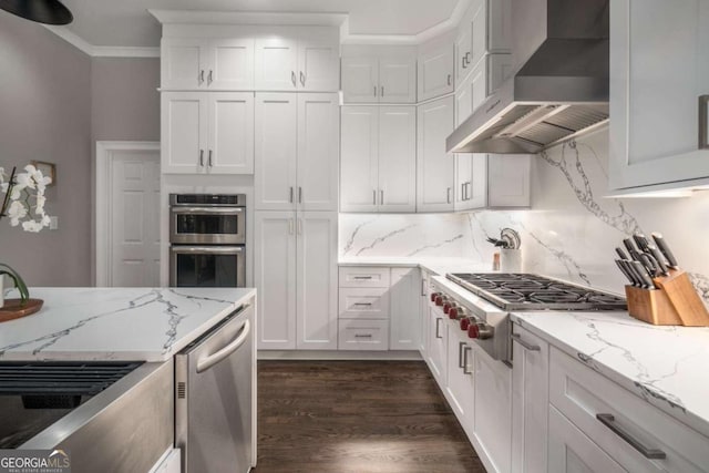 kitchen with white cabinetry, light stone countertops, wall chimney exhaust hood, dark hardwood / wood-style flooring, and appliances with stainless steel finishes