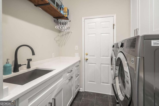 clothes washing area featuring cabinets, washing machine and dryer, and sink