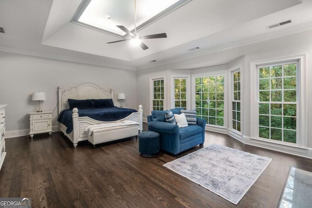 bedroom with ceiling fan, dark hardwood / wood-style floors, crown molding, and a tray ceiling