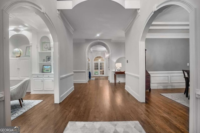 corridor with dark hardwood / wood-style flooring, built in features, and ornamental molding