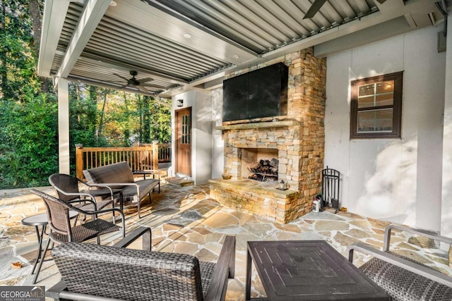 view of patio featuring ceiling fan and an outdoor stone fireplace