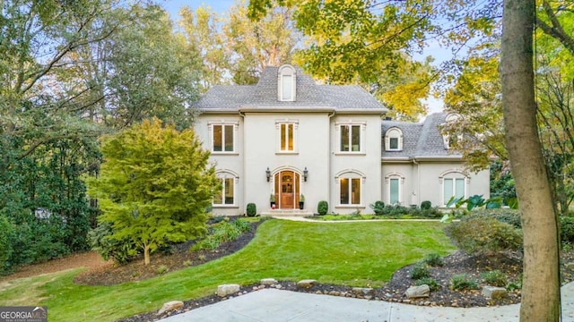 french provincial home with a front lawn