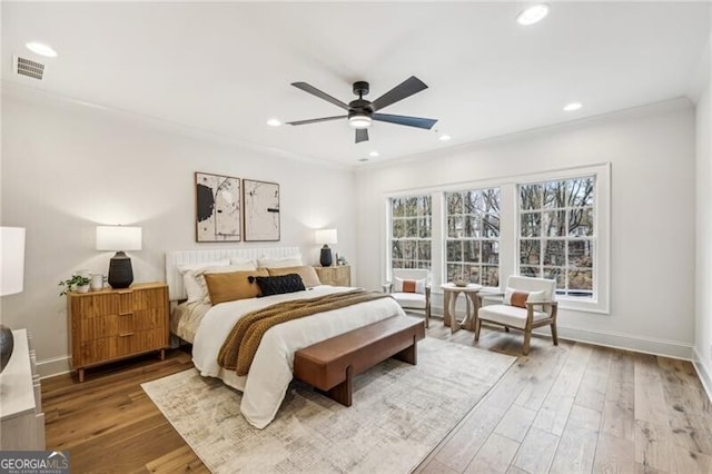 bedroom featuring hardwood / wood-style floors, ceiling fan, and crown molding