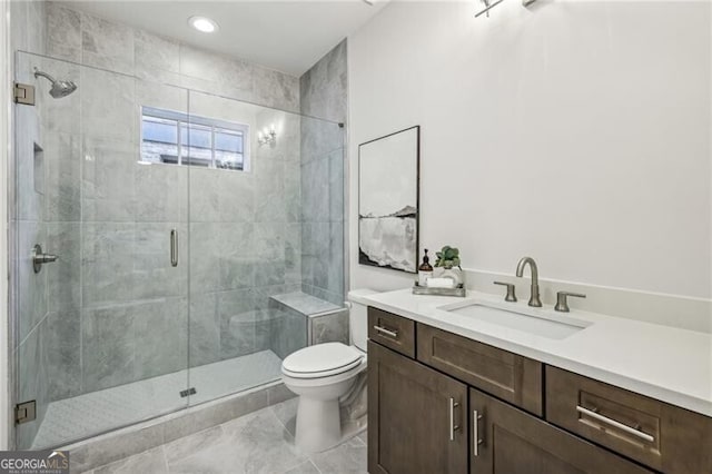 bathroom with vanity, a shower with shower door, and toilet