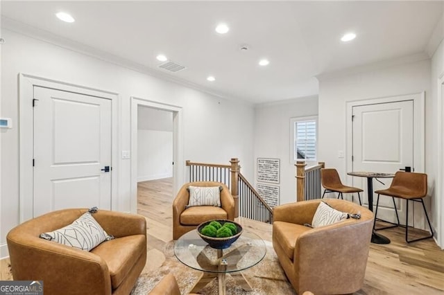 sitting room with light hardwood / wood-style flooring and crown molding