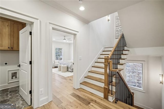 stairs featuring hardwood / wood-style flooring and ceiling fan