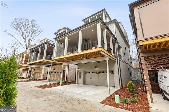 view of front facade with ceiling fan, a garage, and a balcony