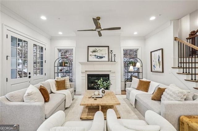 living room featuring ceiling fan and crown molding