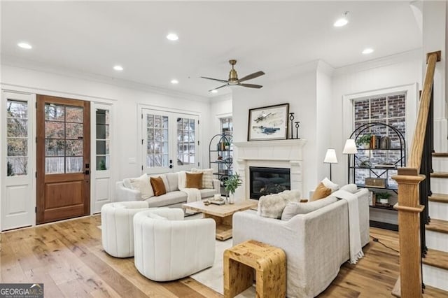 living room featuring ceiling fan, light hardwood / wood-style flooring, and crown molding