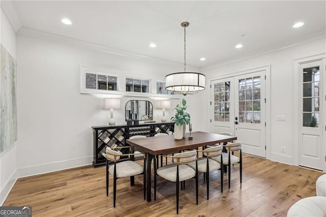 dining space with hardwood / wood-style flooring, crown molding, and french doors