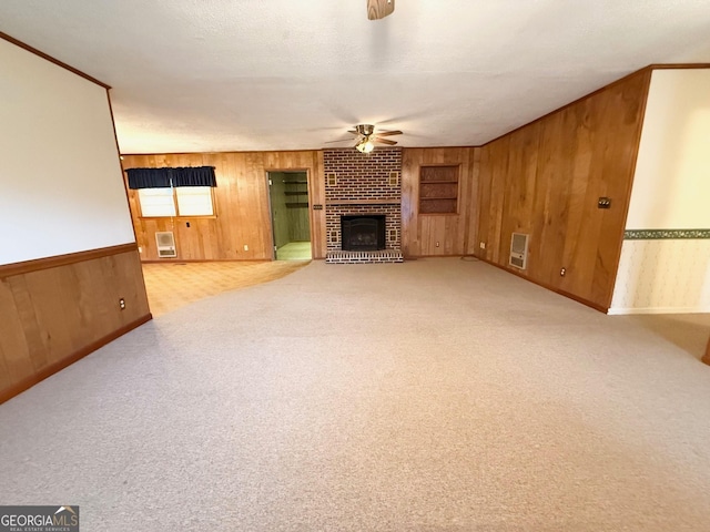 unfurnished living room with ceiling fan, a fireplace, built in features, and a textured ceiling