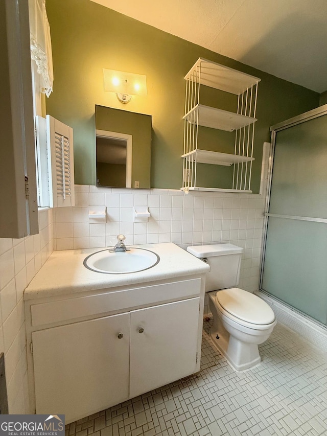 bathroom with decorative backsplash, an enclosed shower, vanity, tile walls, and tile patterned flooring