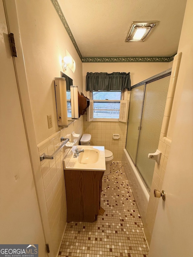 full bathroom featuring tile patterned floors, vanity, toilet, and tile walls