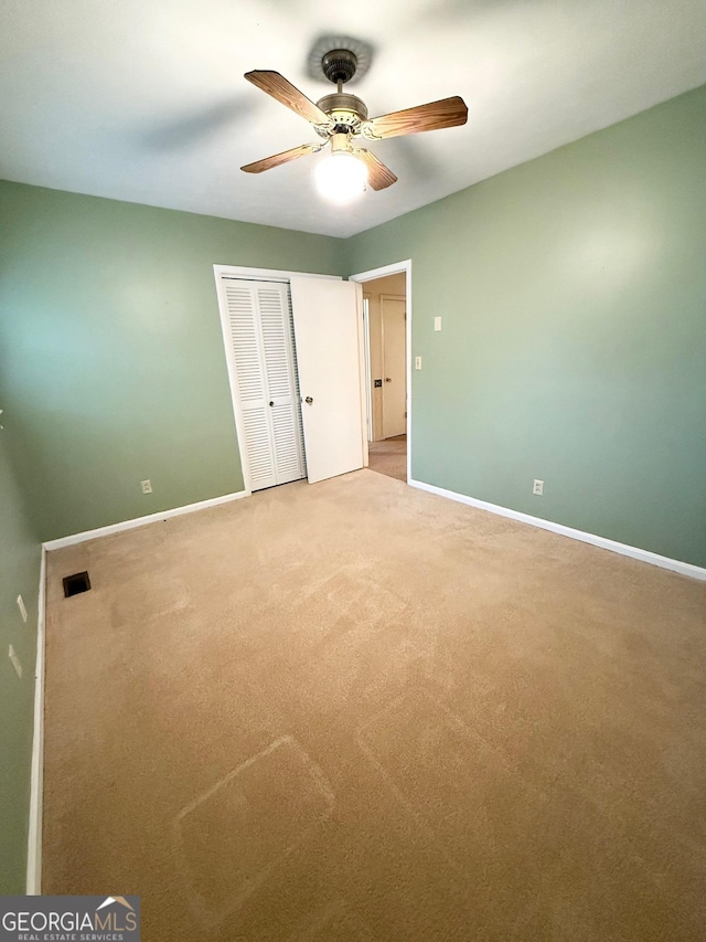 unfurnished bedroom with carpet flooring, ceiling fan, and a closet