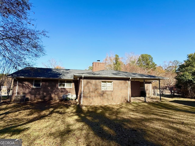 back of house with a lawn and central AC