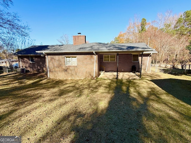 rear view of house featuring a yard and a patio