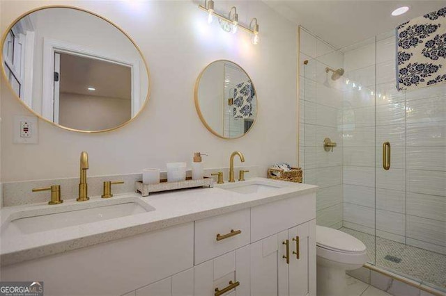 bathroom with tile patterned flooring, a shower with door, vanity, and toilet