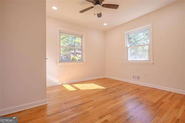 unfurnished room featuring ceiling fan, plenty of natural light, and light wood-type flooring