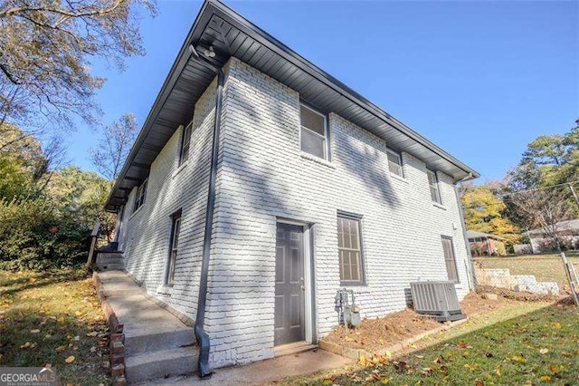 back of house with a yard and central AC unit