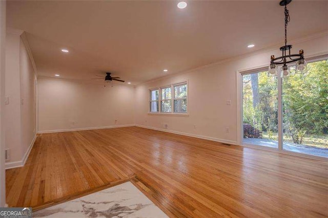 unfurnished living room featuring ceiling fan, ornamental molding, a healthy amount of sunlight, and light hardwood / wood-style floors