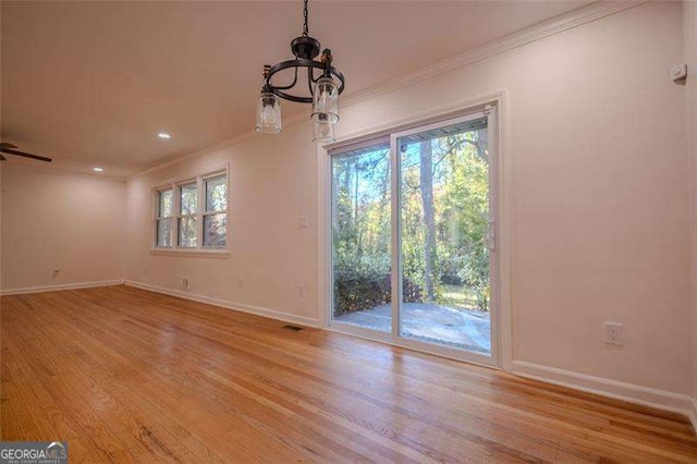 empty room with ceiling fan, light wood-type flooring, and ornamental molding