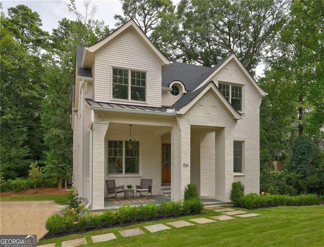 view of front of property with covered porch and a front yard