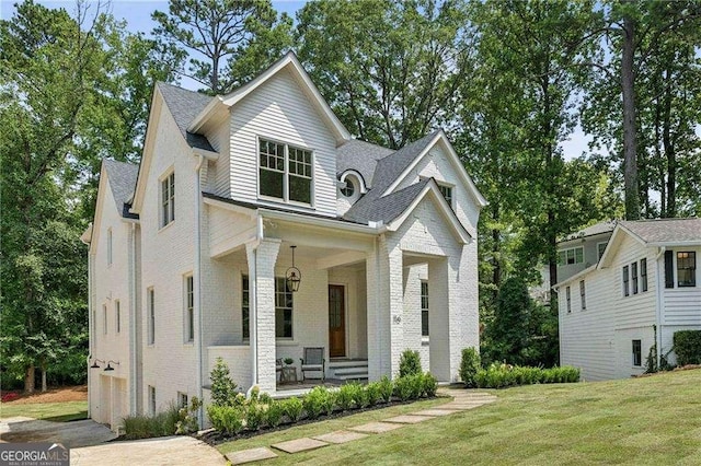 view of front of home with covered porch and a front yard