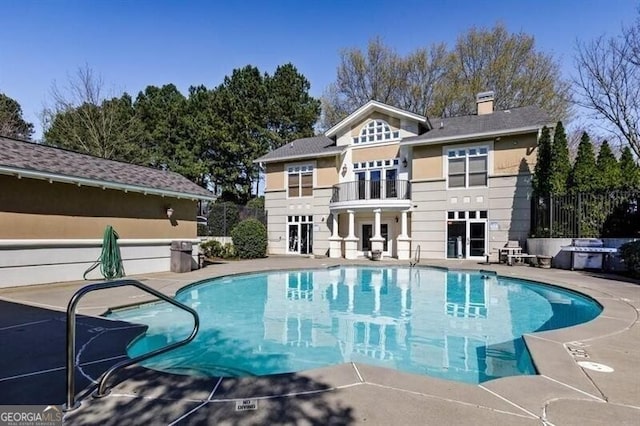 view of swimming pool with grilling area and a patio area