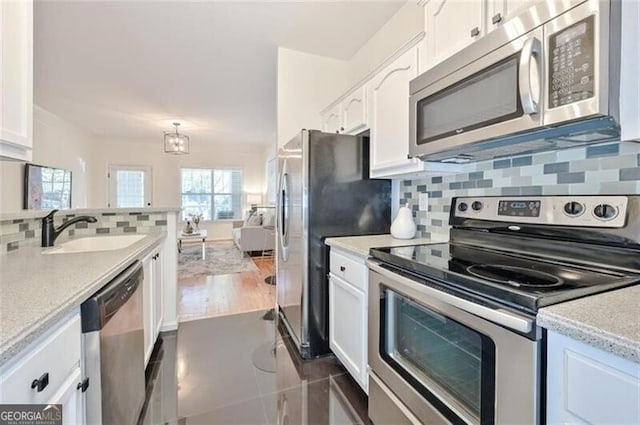 kitchen featuring backsplash, white cabinetry, sink, and stainless steel appliances