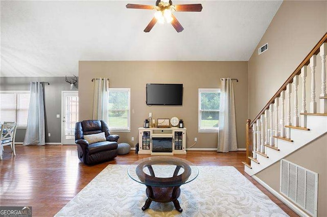 living room with ceiling fan, plenty of natural light, wood-type flooring, and lofted ceiling