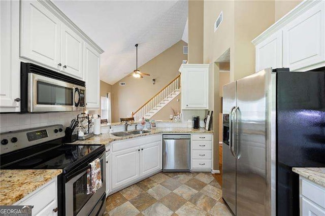 kitchen with ceiling fan, sink, stainless steel appliances, kitchen peninsula, and white cabinets