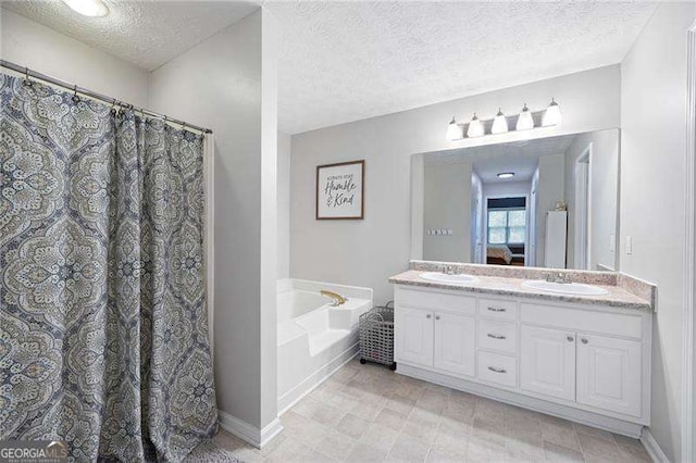 bathroom with a bathtub, vanity, and a textured ceiling