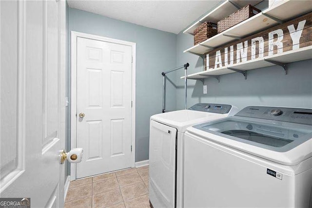 washroom with light tile patterned floors and washing machine and clothes dryer