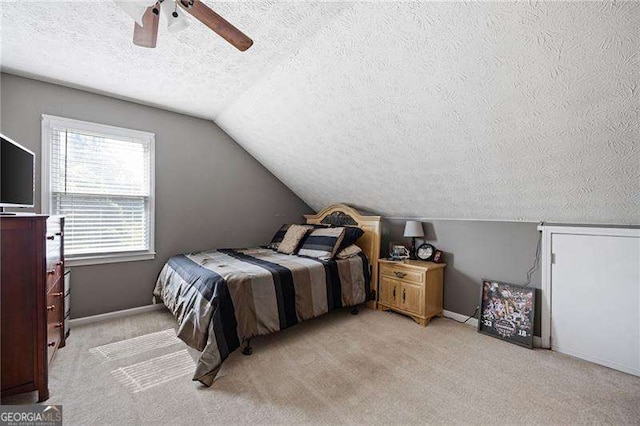 carpeted bedroom featuring ceiling fan, a textured ceiling, and vaulted ceiling