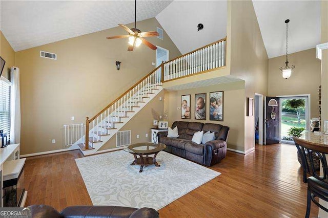 living room with ceiling fan, high vaulted ceiling, and dark hardwood / wood-style floors