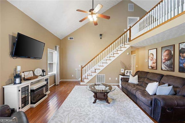 living room featuring ceiling fan, hardwood / wood-style floors, and high vaulted ceiling