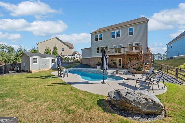 view of swimming pool featuring a shed, a wooden deck, a yard, and a patio